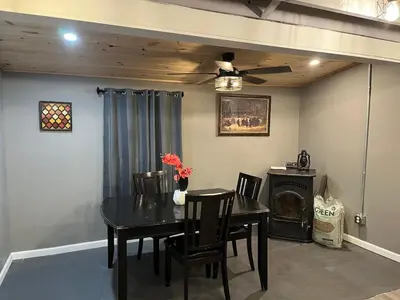 a dining room with a table and chairs and a ceiling fan at Brooks bay in Lake Luzerne