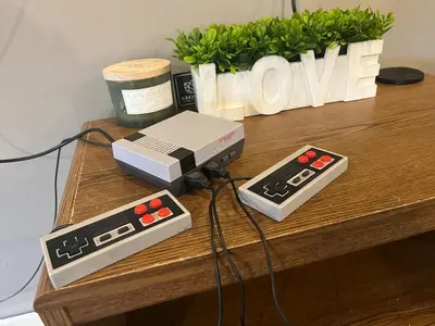 a nintendo wii game system and two controllers on a table at Brooks bay in Lake Luzerne