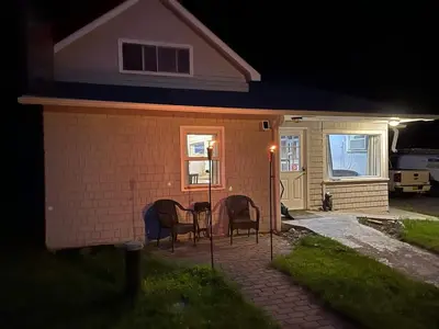 a house with two chairs and a table in the yard at Brooks bay in Lake Luzerne