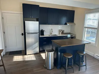 a kitchen with blue cabinets and a stainless steel refrigerator at The Innwoods - One Bedroom Apartment in Tannersville