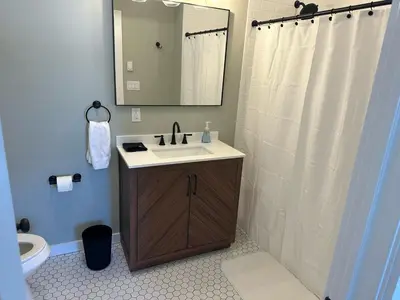 a bathroom with a sink and a shower with a mirror at The Innwoods - One Bedroom Apartment in Tannersville