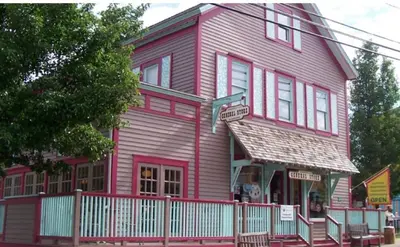 a red house with a white fence in front of it at The Innwoods - One Bedroom Apartment in Tannersville