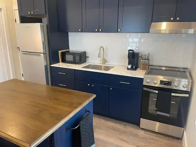 a kitchen with blue cabinets and a sink and a stove at The Innwoods - One Bedroom Apartment in Tannersville