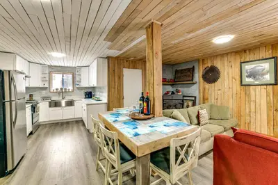 a kitchen and living room with a table and a couch at Mtn-View Deck and Grill Creekside Catskills Cabin! in Equinunk