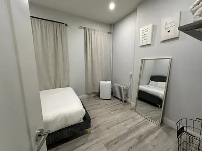 a small bedroom with a mirror and a bed at Adam Clayton Apartment in New York