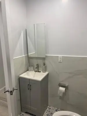 a bathroom with a sink and a mirror and a toilet at Adam Clayton Apartment in New York