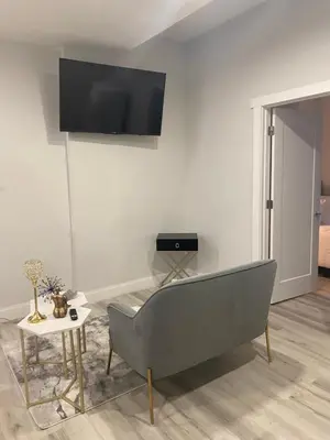 a living room with a couch and a tv on the wall at Adam Clayton Apartment in New York
