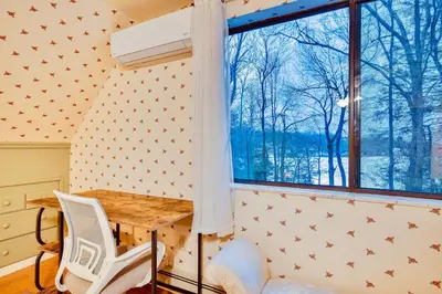 a room with a table and a window at Lakehouse with Boats, MiniGolf, Sauna, HotTub, Swings and Playground! in Pocono Summit