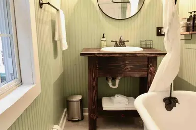 a bathroom with a sink and a mirror and a tub at Bright, Airy Home in Hudson! in Hudson