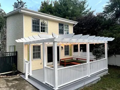 a house with a porch with a white pergola at Bright, Airy Home in Hudson! in Hudson