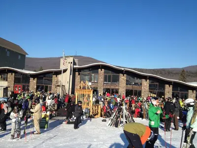 a crowd of people standing outside of a building in the snow at 4BR ski on ski off Hunter Mountain Highlands Condo in Hunter