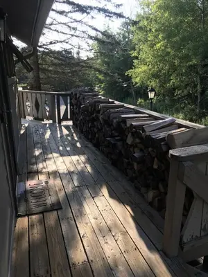 a wooden deck with a stone retaining wall at 4BR ski on ski off Hunter Mountain Highlands Condo in Hunter