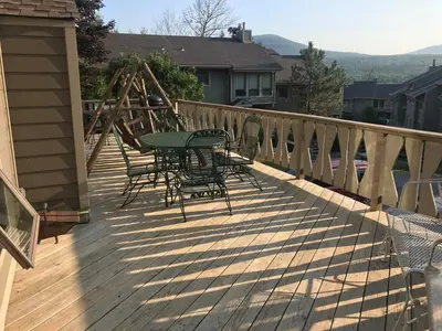 a patio with a table and chairs on a deck at 4BR ski on ski off Hunter Mountain Highlands Condo in Hunter