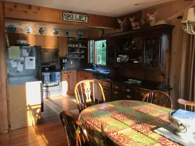 a kitchen with a table and a kitchen with a refrigerator at 4BR ski on ski off Hunter Mountain Highlands Condo in Hunter