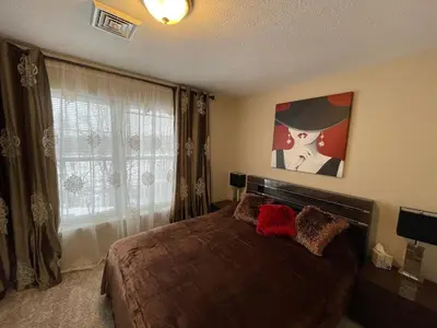 a bedroom with a bed and a painting on the wall at Gorgeous house private pool hot tub playroom in Long Pond