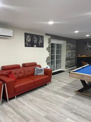 a living room with a red couch and a pool table at Gorgeous house private pool hot tub playroom in Long Pond