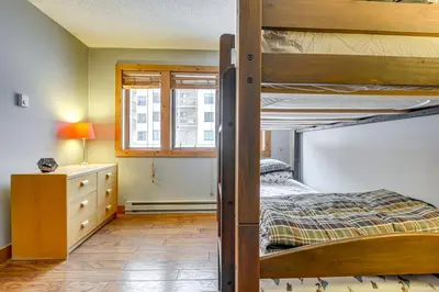 a bedroom with two bunk beds and a dresser at Less Than 1 Mi to Mt Snow Charming Condo with Fireplace in Dover