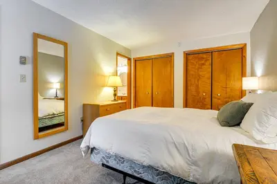 a bedroom with a large white bed and a mirror at Less Than 1 Mi to Mt Snow Charming Condo with Fireplace in Dover