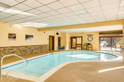 a large pool in a building with a large at Less Than 1 Mi to Mt Snow Charming Condo with Fireplace in Dover