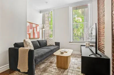 a living room with a couch and a table at Blueground Nolita wd ac nr Little Italy NYC-1570 in New York