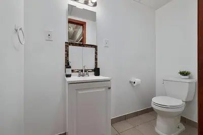 a white bathroom with a toilet and a mirror at Peaceful Paradise , Dream Holiday Home in Woodridge in Mountain Dale