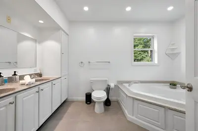 a white bathroom with a tub and a toilet at Peaceful Paradise , Dream Holiday Home in Woodridge in Mountain Dale