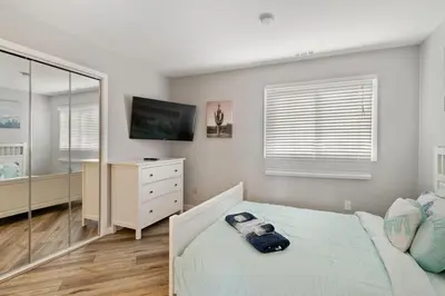 a bedroom with a bed and a tv and a mirror at Mountain Creek Townhouse in Vernon Township