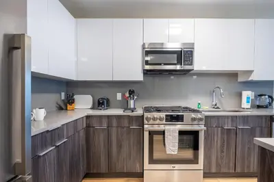 a kitchen with white cabinets and a stove top oven at Modern Apt Downtown in Stamford