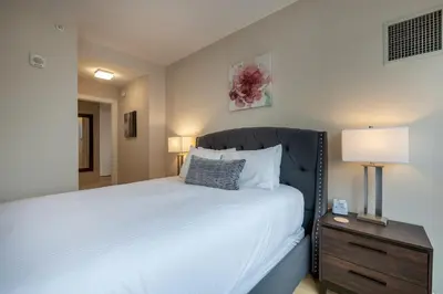 a bedroom with a large white bed and a nightstand at Modern Apt Downtown in Stamford