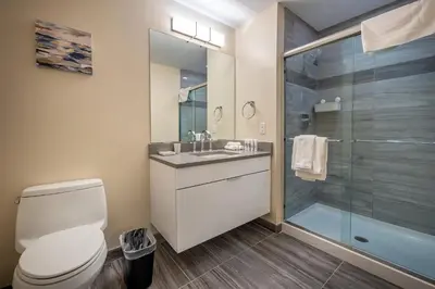 a bathroom with a toilet and a glass shower at Modern Apt Downtown in Stamford