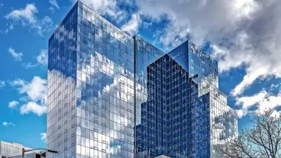 a tall glass building against a cloudy sky at Modern Apt Downtown in Stamford