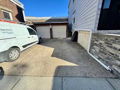 a white van parked in a driveway next to a garage at Cozy 1 BR, walk to subway, Free WiFi & Parking in Belleville