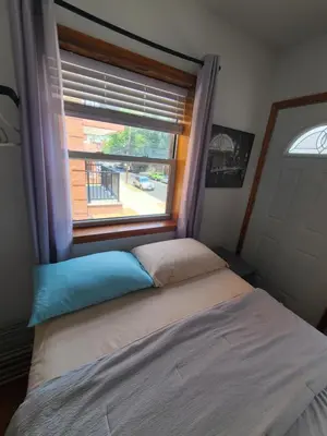 a bed in a bedroom with a window at Nice rooms Woodside in Queens