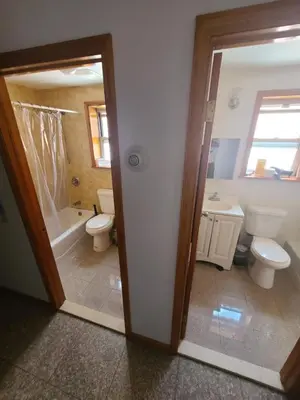 a bathroom with a toilet and a tub and a sink at Nice rooms Woodside in Queens
