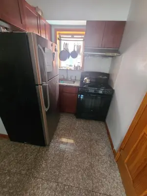 a small kitchen with a refrigerator and a sink at Nice rooms Woodside in Queens