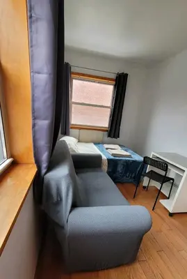 a room with a couch and a bed and a window at Nice rooms Woodside in Queens
