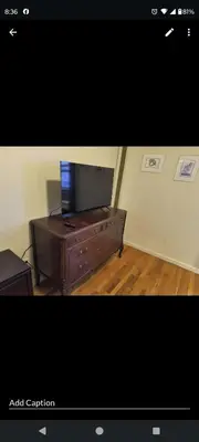 a living room with a flat screen tv on a dresser at My apartment in New York