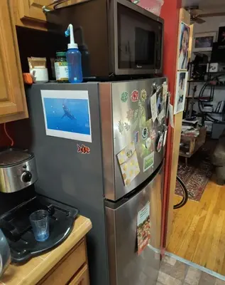 a kitchen with a stainless steel refrigerator with magnets at My apartment in New York