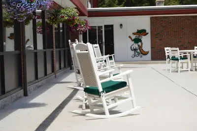 a row of white chairs sitting on a sidewalk at The Inn at Crumpin-Fox in Bernardston