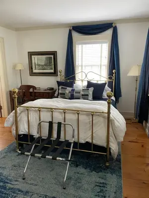 a bedroom with a large bed with blue curtains at White hollow farm in Salisbury