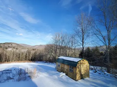 a small building in the snow in a field at Pleasant Brook Cottage in Roxbury