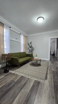 a living room with a green couch and a table at Serenity Haven in Irvington