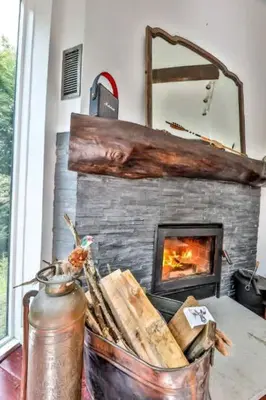 a fireplace with a basket of bread in front of it at Unique and Private 25ft Waterfall House in Hunter in Elka Park