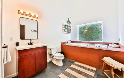 a bathroom with a tub and a toilet and a sink at Unique and Private 25ft Waterfall House in Hunter in Elka Park