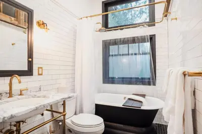 a bathroom with a tub and a toilet and a sink at Chic Catskills Cabin with Hot Tub and Fire Pit in Lanesville
