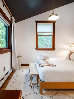 a bedroom with a bed and a window at Chic Catskills Cabin with Hot Tub and Fire Pit in Lanesville