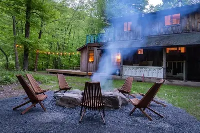 a group of four chairs in front of a house at Chic Catskills Cabin with Hot Tub and Fire Pit in Lanesville