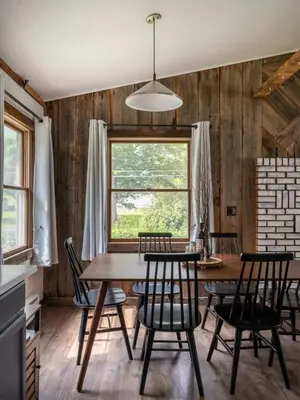 a dining room with a table and chairs and a window at Hunter Mountain View Cabin in Lanesville