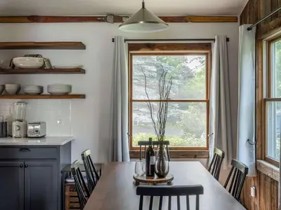 a kitchen with a table with chairs and a window at Hunter Mountain View Cabin in Lanesville