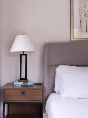 a bed with a night stand with a lamp on it at Hunter Mountain View Cabin in Lanesville